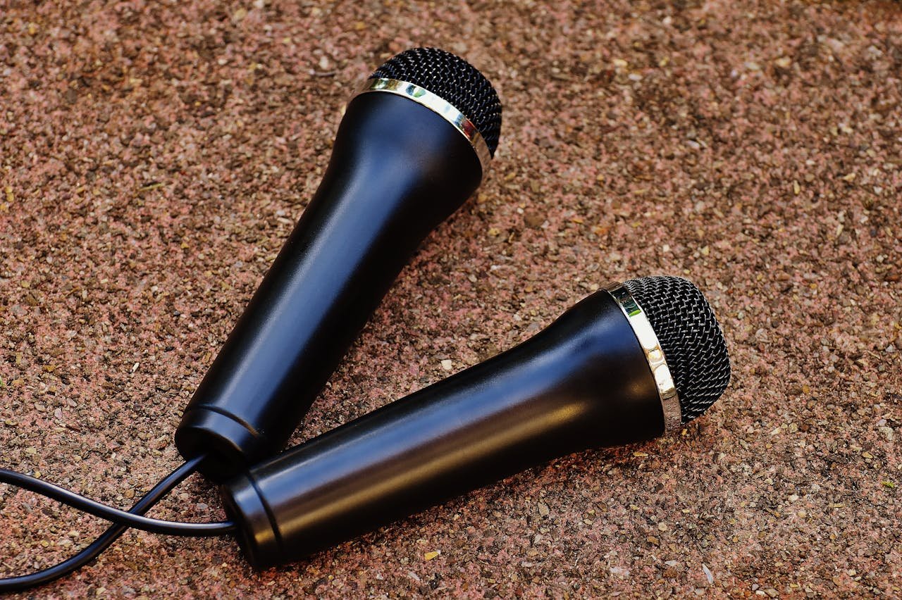 Close-up of two black handheld microphones on a textured background, perfect for audio themes.